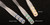 Three synthetic oboe reeds are displayed on a black background. The reeds are labeled 'Medium-Hard' with blue bands, 'Medium-Soft' with green bands, and 'Medium' with yellow bands.