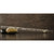 Transparent piccolo with white dragon, resting horizontally on a brown surface and supported by a black stone and a beige stone.