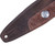 Detail of end with embossed button design on a Levy's two-tone brown guitar strap.