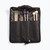 An open black nylon mallet bag revealing four pairs of drumsticks and mallets tucked into its internal pockets: wood-tip drumsticks, small black hard-head mallets, purple yarn mallets, and white felt mallets.