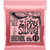 A close-up of Ernie Ball Zippy Slinky guitar strings packaging with an eagle logo on a pink background.