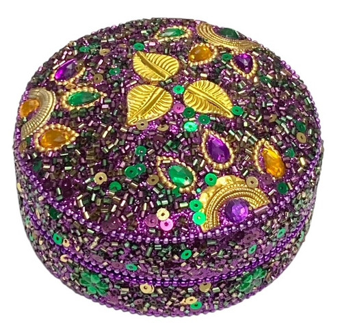 Round Mardi Gras Jeweled Box. Covered in purple, green, and gold sequins, beads, and sparkling costume gems, as well as purple glitter. Measures 4in.