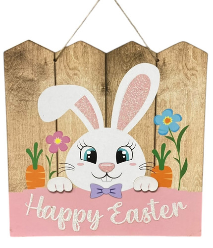 Bunny with Fence Plaque. A white bunny with one lopsided ear, holding a pink panel in front of a brown fence decorated with flowers and carrots, and featuring white glitter text that says "Happy Easter." Fiberboard with jute hanger. Measures 11.5in.