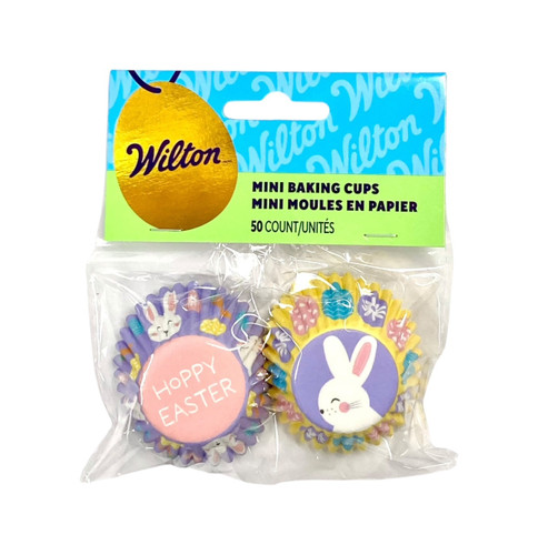 Mini Easter Baking Cups. This set includes two designs: one features a lavender background with a pattern of white bunnies, colorful eggs, and carrots, with a pink bottom that reads "HOPPY EASTER" in white text. The other has a yellow background with colorful eggs, and a lavender bottom showcasing a white bunny. Package includes 50 count baking cups measuring 1.25inches.