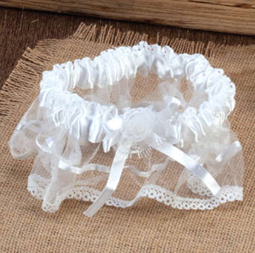 White Wedding Garter. Designed with delicate lace and a soft satin ribbon, accented with a ribbon flower. One size fits most.