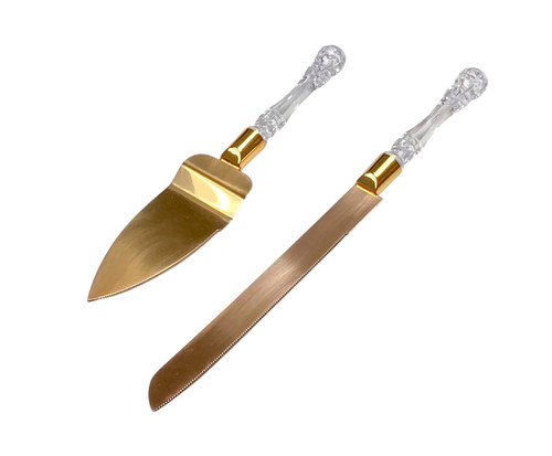 Gold Wedding Cake Knife Set. Featuring gold metal blades and clear handles. Includes 1 count 13in knife and 1 count 10in server.