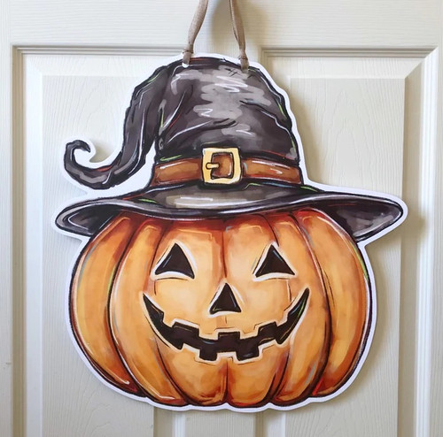Jack O Lantern Door Hanger. Featuring a painterly illustration of a smiling Jack O Lantern wearing a twisted witch hat, this design is printed on a white PVC sign, hanging by a burlap ribbon, waterproof and perfect for indoor or outdoor use. Measures 19.5in x 20in without ribbon, .25in thick material.