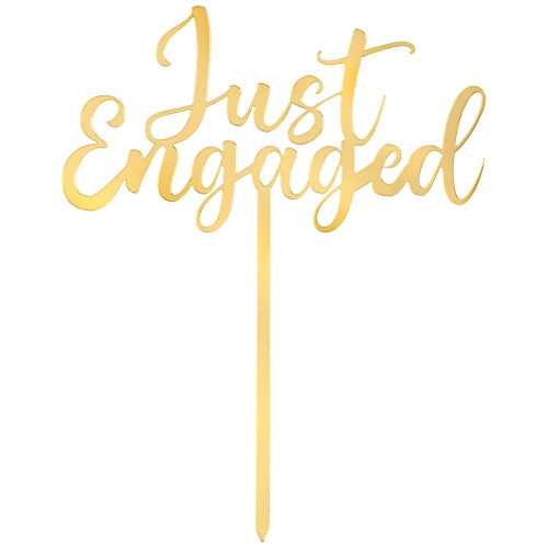 Just Engaged Gold Cake Topper. This acrylic cake topper has a gold finish and features the text "Just Engaged" in script with one word centered over the other. Measures about 6.5in x 5in.