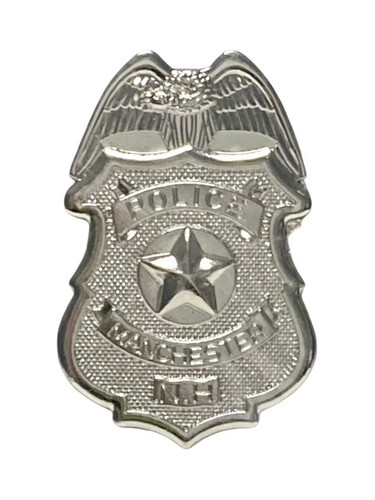 This silver tone metal Police Badge features the text "POLICE," "MANCHESTER," and "N.H." Measures 3.2in x 2in.