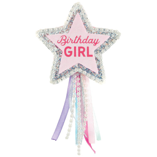 Birthday Girl Star Ribbon. This pink star shaped piece is decorated with a trim of silver glitter and plastic white pearl beads, a tail of pearls and multicolor ribbon, and "Birthday GIRL" in dark pink text. Measures 3.3in, about 6.25in with tail.
