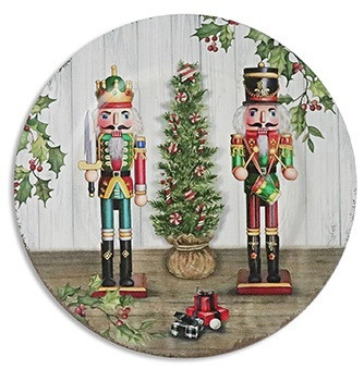 Vintage Nutcracker Charger. This plastic plate features a picture of two nutcrackers standing beside a Christmas Tree. One version is mostly red and green in front of a white wooden background. Desired style not guaranteed. Measures 13in.
