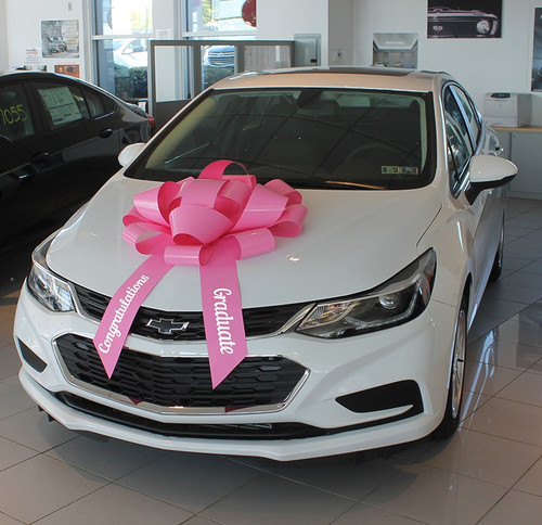 This Pink Car Bow is made of weather resistant PVC with a scratch proof suction cup base. It includes two ribbon tails with "Congratulations" and "Graduate" in white text, measuring 30in x 5in.