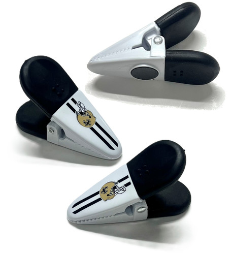 New Orleans Saints Bag Clips. This set features black and white plastic clips with a gold football helmet logo. A magnet on the underside allows them to be kept on the fridge when not in use for convenience. Package includes 3 count clips measuring about 3.25in.