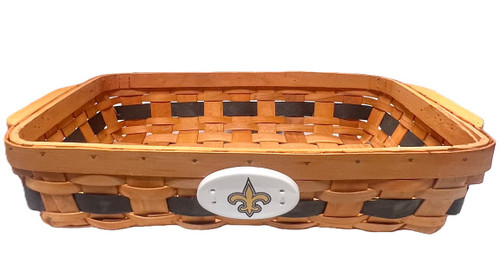 New Orleans Saints Casserole Basket. This orange tinted wooden basket features a single black stripe along the side and a white ceramic medallion with a gold Saints fleur de lis. Measures about 13in long (15.7in with side handles) x 9in wide x 3in tall.