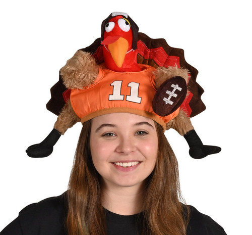 Plush Touchdown Turkey Hat. This hat features a plush turkey wearing a helmet and an orange jersey with the number "11," a football attached to one of its wings. One size fits most.