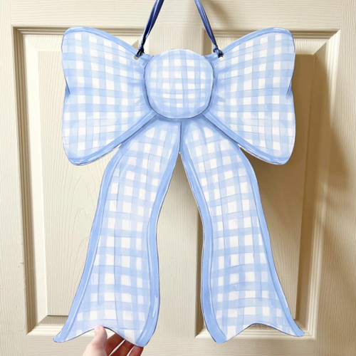 Double Sided Gingham Bow Door Hanger - Blue side. Featuring a painterly illustration of a gingham bow with pink and white on one side and blue and white on the other, this design is printed on a white PVC sign, hanging on a burlap ribbon, waterproof and perfect for indoor or outdoor use. Measures 21in x 16in without ribbon, .25in thick material.