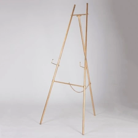 Gold Metal Easel. Perfect for weddings, showers, photo shoots, or parties, it provides sturdy support for an event sign. Measures 60in tall.