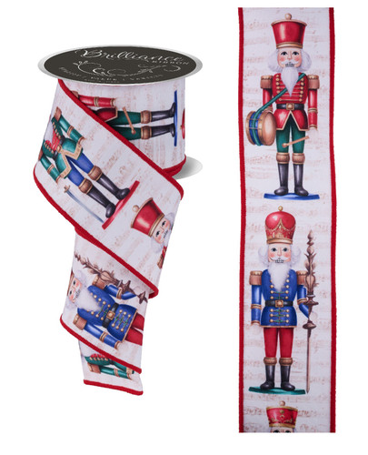 Nutcracker Ribbon. This ivory polyester ribbon features colorful printed nutcrackers in red, gold, green, and blue, holding staffs, drums, and swords, over a background with lines of music notes with red borders. Measures 2.5in x 10yds.