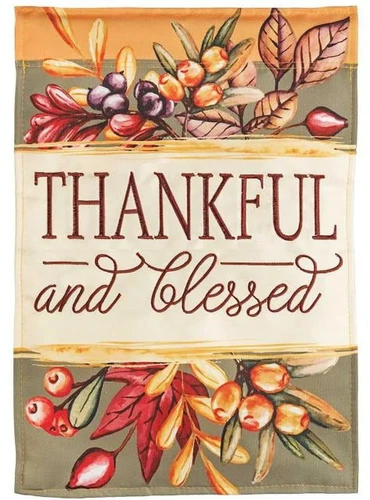 Thankful and Blessed Garden Flag. This double applique flag features a "THANKFUL and blessed" in a combination of capital print and script letters in between sprigs of fall foliage. Measures 13in x 18in.