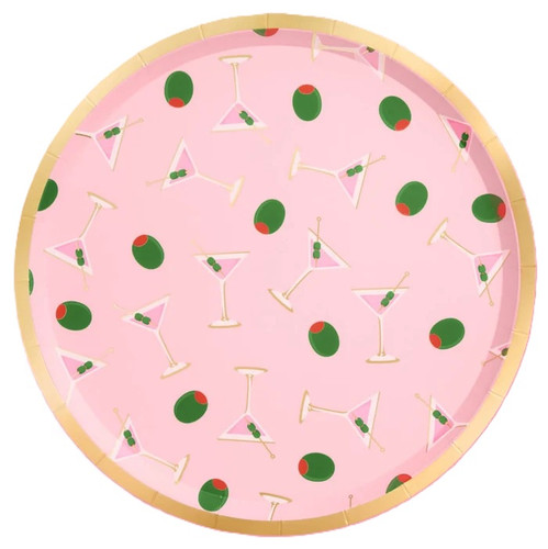 Tini Bit Older Dirty Martini Luncheon Plates. These shallow, round paper plates feature a light pink background with a pattern of pink martinis and green olives, accented with a gold foil trim. Not microwave safe. Package includes 25 count plates measuring 9in.