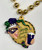 Beer Bead Necklace. This necklace features gold metallic beads with a shaped pendant (2.5in) of a metallic gold circle along with the profile of a Jester's face and a hand holding a beer in a purple cup. One size fits most.
