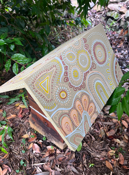 Beehive roof decorated with detailed earth-toned circular, floral and flowing hand-painted patterns.