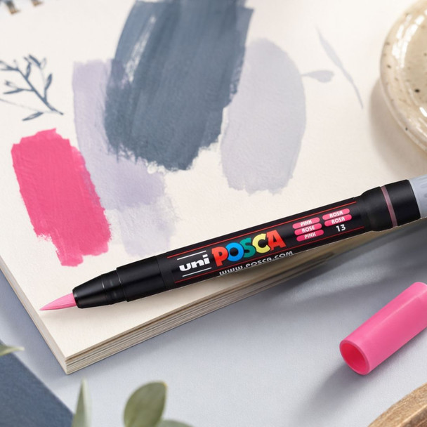 POSCA PCF-350 pink brush marker displayed on an artist sketchbook with pink, grey and slate grey colour swatches. | PoscART