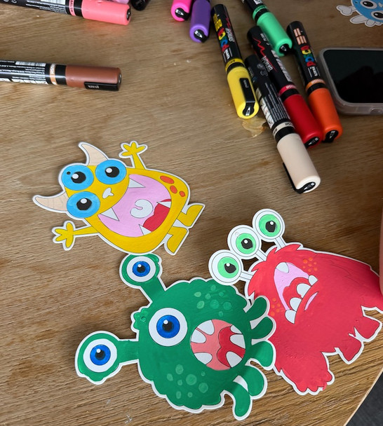 POSCA Colour In Monster Cards showing uncoloured line art monsters alongside fully coloured designs to demonstrate creative customisation.