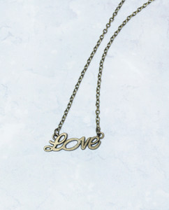 Lagom Love Necklace Bronze detailed front view on marble background Lagom Love Necklace Bronze detailed front view on marble background