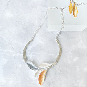 Elegant enamelled necklace and earrings set with lily flower shaped pendants in shades of yellow and grey. Elegant enamelled necklace and earrings set with lily flower shaped pendants in shades of yellow and grey.