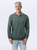 Just Sweatshirts 3 button polo in pine sand color, 100% cotton, green long sleeve shirt on a man.