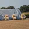 30'x48' silver polyester hay tarp protecting the bales of hay underneath.