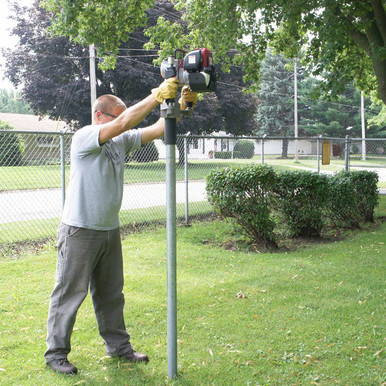 Side Handle Rhino Gas Driver, a person operating a gas-powered tool with a side handle outdoors in a park setting.