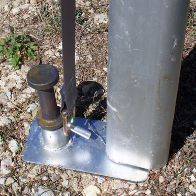 42" x 1" Double Head Tent Stake, close-up view showing the stake secured in ground with metal base plate and attached to a pole.