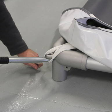 Pinnacle Tent Pry Bar, close-up of the tool being used to manipulate or pry equipment near a white tent or awning.