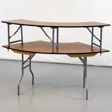 Celina Tent Serpentine Bar Top Outer Edge, a curved bar table with a two-tone wooden top and metal frame with an additional lower shelf.
