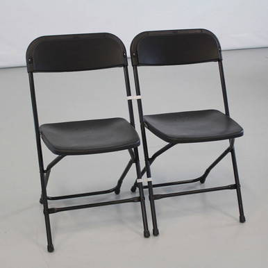 Black Poly Chair Ganging Clip, two black folding chairs connected with a ganging clip.