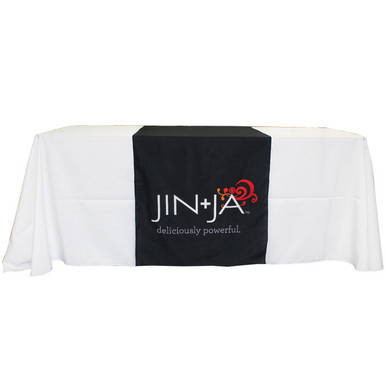 Table Runner, a long white table runner with a black center section featuring the JINJIA logo and the phrase 'deliciously powerful'.