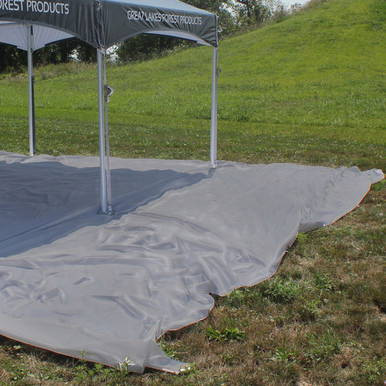 25' x 45' Polyester Drop Cloth, an outdoor protective cover spread on grass under a canopy tent for painting or construction projects.
