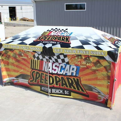 8' x 20' Royalty SW Full Print, NASCAR Speedpark event tent with vibrant racing-themed graphics and promotional text for free soda offer.