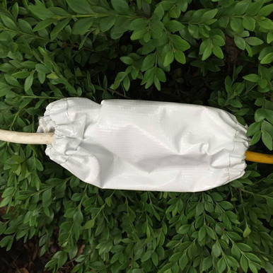 Ratchet Cover, Small, protecting a tool from dirt and moisture, outdoor setting with green foliage in the background.