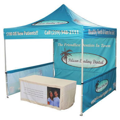 Celina Tent Fast Shade Package 10-7, outdoor promotional event tent with blue canopy, printed advertising banners, and a table with promotional materials.