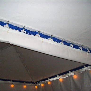 30' - White Vinyl Water Gutter, close-up view of the white vinyl water gutter installed under a tent ceiling with lighting fixtures.