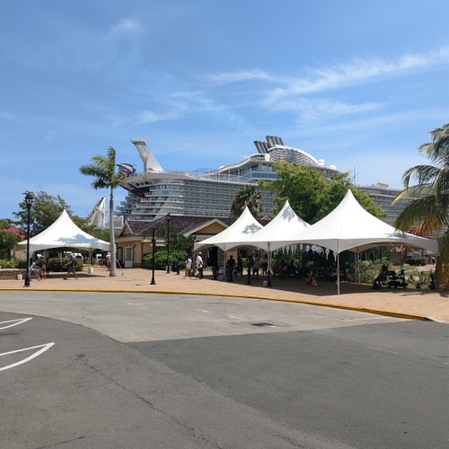 Event Rental Startup Revenue Bundle, image of outdoor event setup with white tents and people at a venue near a cruise ship dock in a sunny setting.