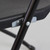Bellbrook Black Poly Chair, close-up view of the chair's black plastic seat and metal supporting frame with visible mounting hardware.