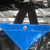15' x 54' Hay Tarp, close-up of the blue tarp with reinforced grommet and black straps for secure fastening.