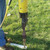 2'' Stake Driver Bit, a close-up photo of a 2-inch drive bit attached to a yellow post driver tool on a grassy surface for driving stakes into the ground.
