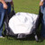 E-Z Equipment Carrier, a portable gear bag designed for outdoor use, being held open by two people on a grassy field.