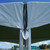15' Water Gutter for Pinnacle, close-up view of the gutter installed on canopy support poles, showing the protective cover and attachment details.