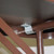 Celina Tent 8' Laminate Banquet Table, close-up of the metal support bracket underneath the brown laminate surface.